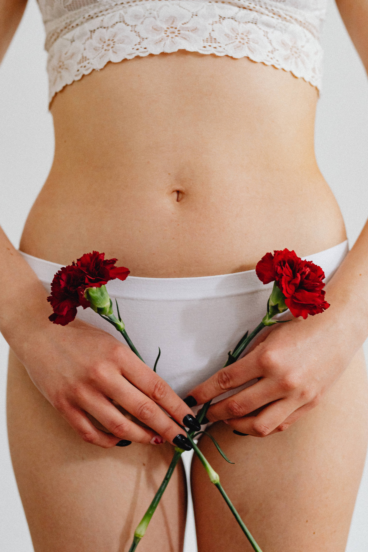 Woman in Lingerie Holding Red Flowers